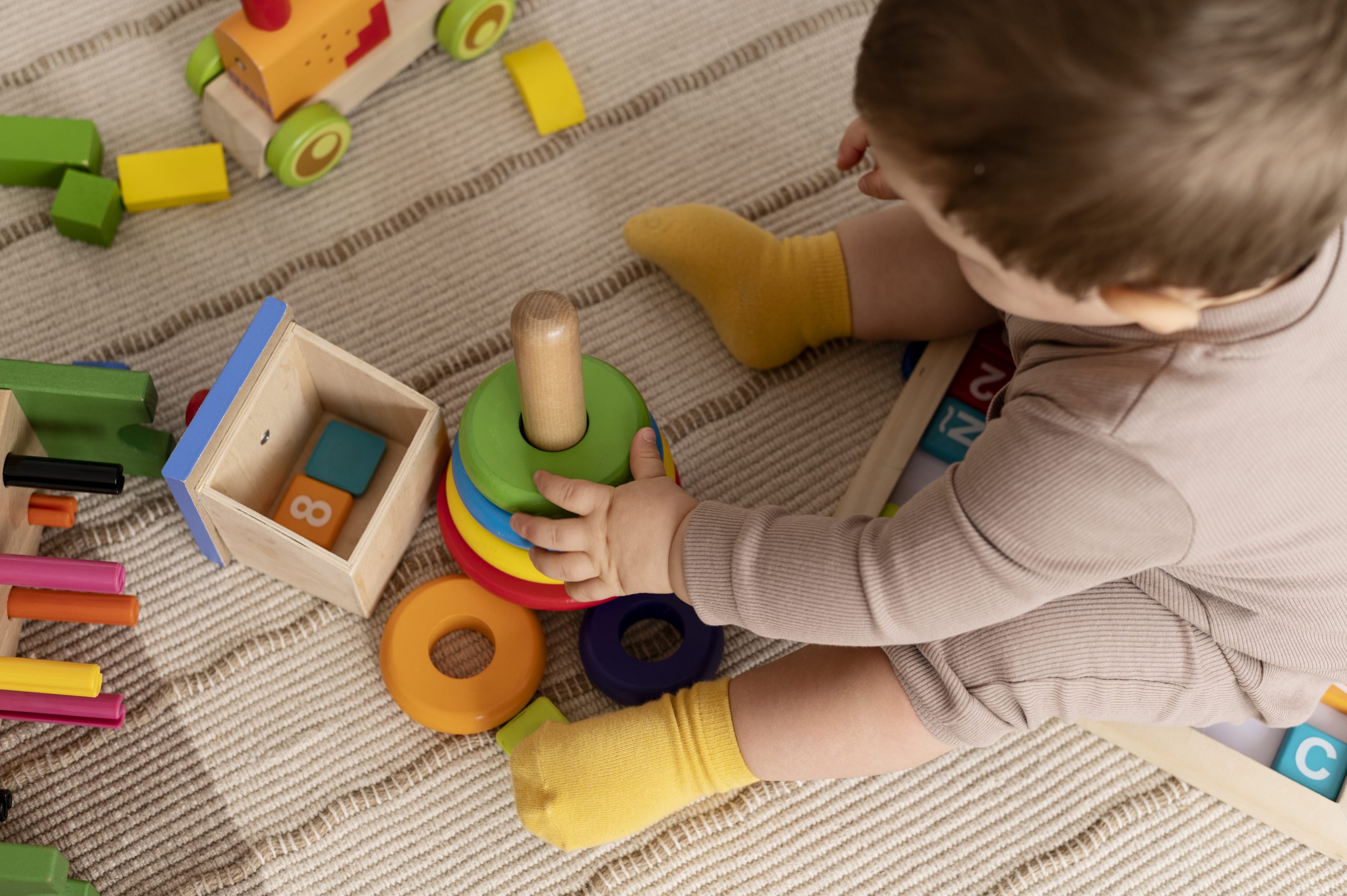 High Angle Kid Playing With Colorful Toys
